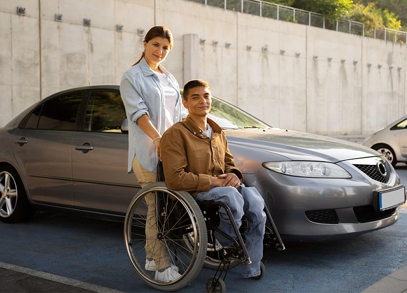 Wheelchair user next to parked car