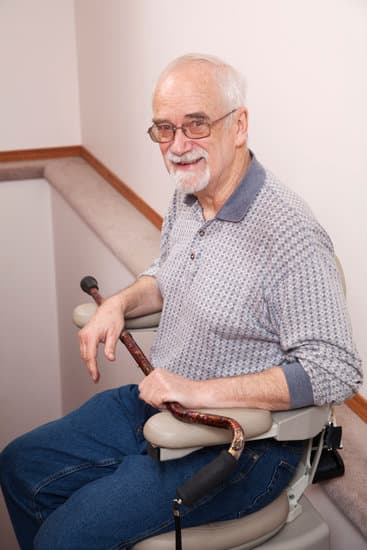 Senior using his rent a stairlift in home: Assisted Living