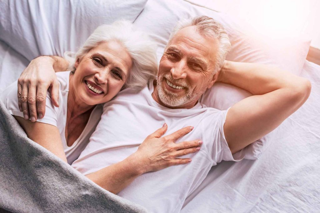 Incontinence Aids couple in bed happy. Modern Mobility incontinence experts