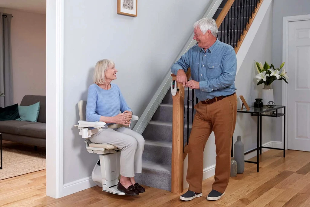 Couple talking at bottom of Stairlift with Easy Hinge